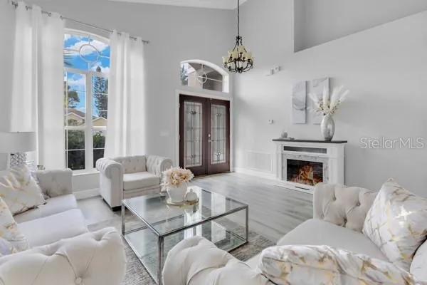a living room with furniture a chandelier and a fireplace