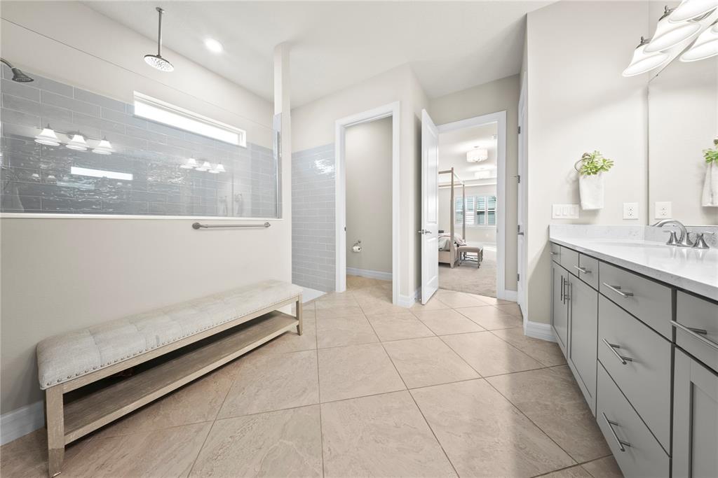 7905 Wandering Way Orlando, FL 32836 - Photo 30 of 70 a spacious bathroom with a granite countertop sink a mirror and a shower