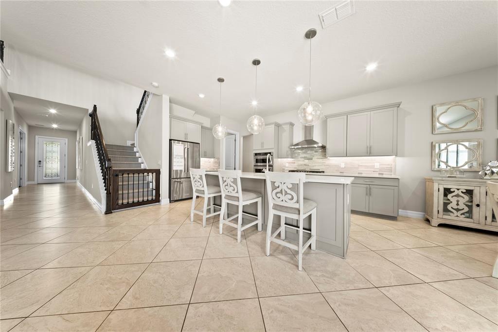 7905 Wandering Way Orlando, FL 32836 - Photo 3 of 70 a kitchen with stainless steel appliances kitchen island granite countertop a sink a stove a refrigerator and cabinets