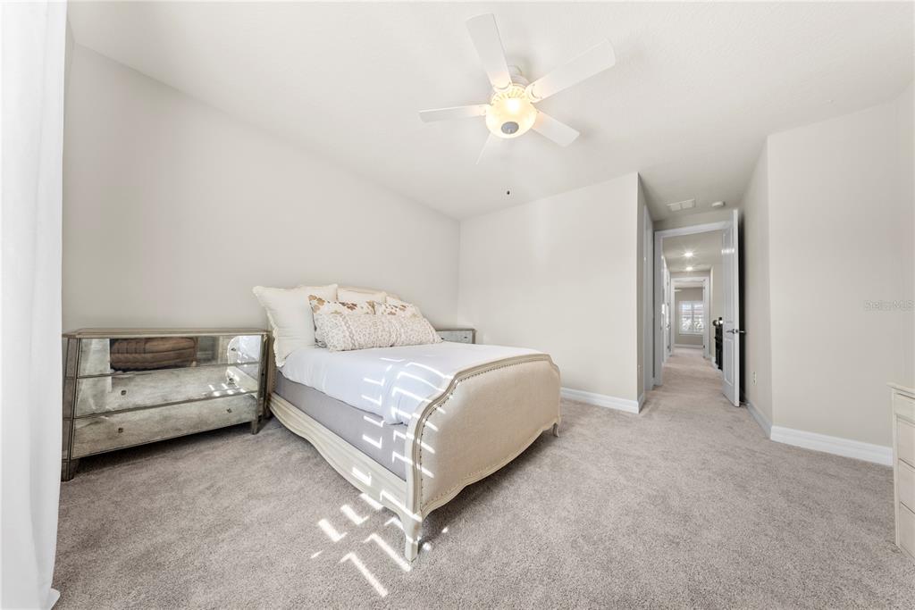 7905 Wandering Way Orlando, FL 32836 - Photo 40 of 70 a spacious bedroom with a bed and a chandelier