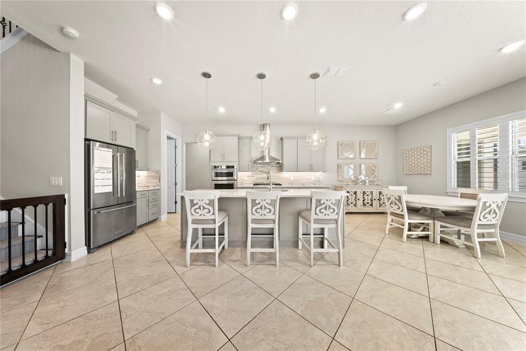 7905 Wandering Way Orlando, FL 32836 - Photo 4 of 70 a dining hall with stainless steel appliances a dining table and chairs