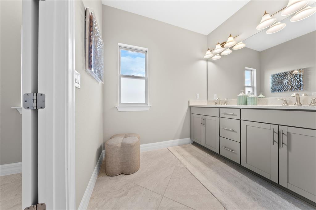 7905 Wandering Way Orlando, FL 32836 - Photo 42 of 70 a bathroom with a double vanity sink a mirror and a bathtub