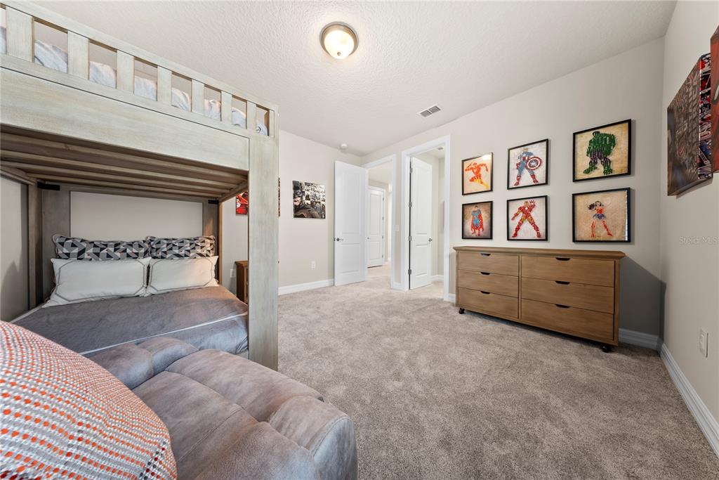 7905 Wandering Way Orlando, FL 32836 - Photo 49 of 70 a spacious bedroom with a bed and a chandelier