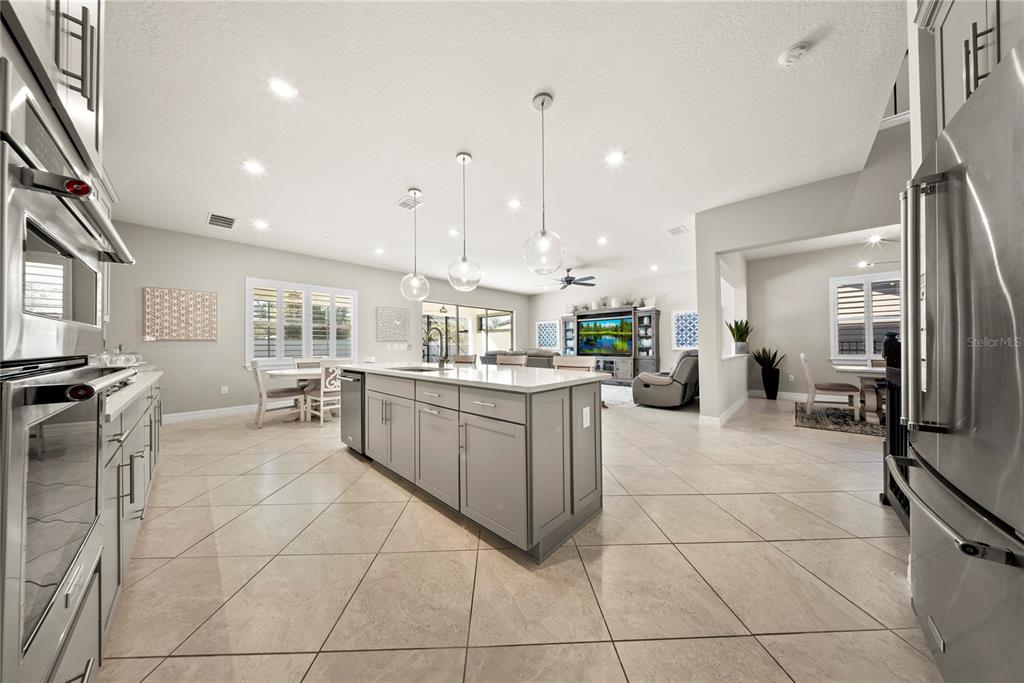 7905 Wandering Way Orlando, FL 32836 - Photo 5 of 70 a kitchen with stainless steel appliances kitchen island granite countertop a refrigerator a stove a oven and white cabinets with island