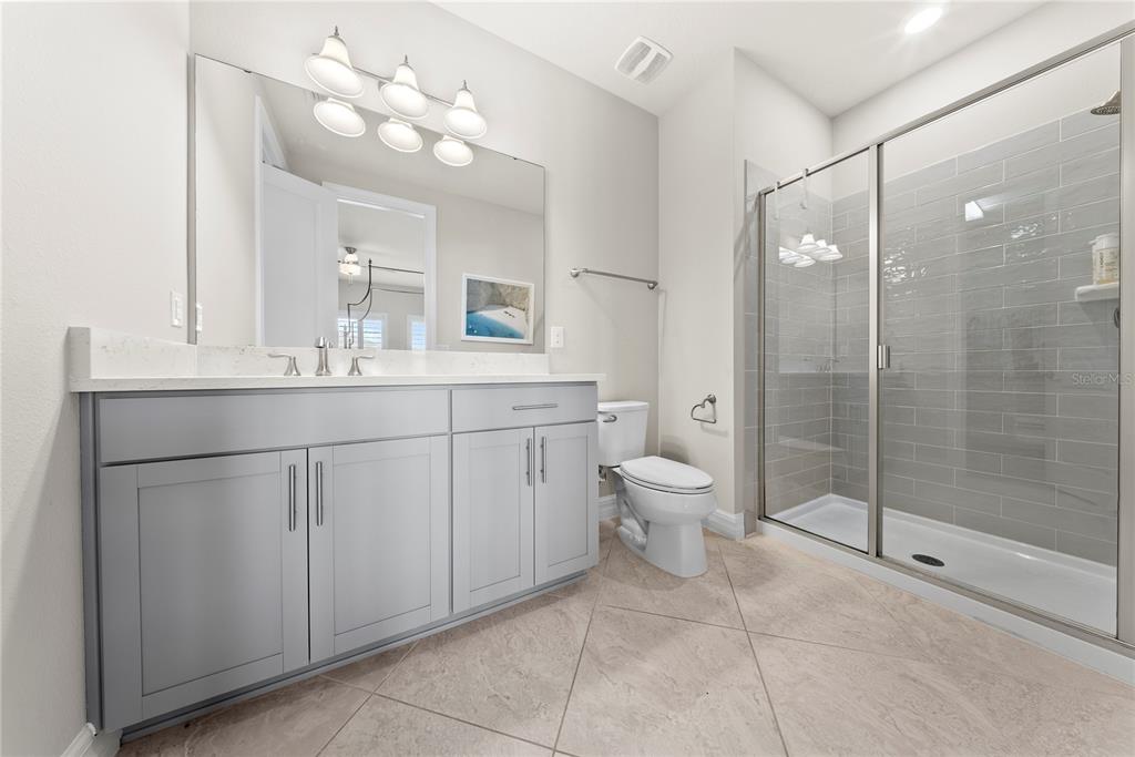 7905 Wandering Way Orlando, FL 32836 - Photo 56 of 70 a spacious bathroom with a shower sink mirror and toilet
