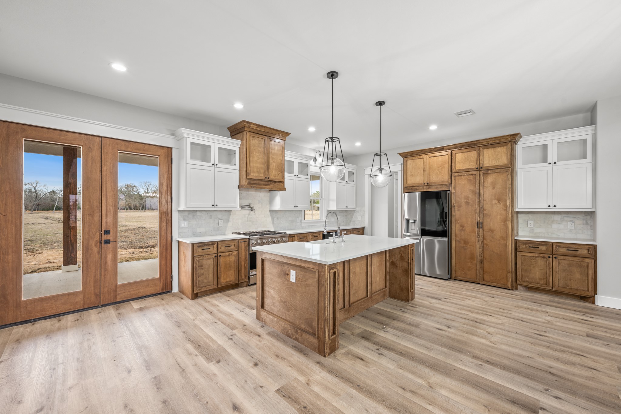 95 Longhorn Loop New Waverly, TX 77358 - Photo 14 of 50 a large kitchen with stainless steel appliances granite countertop a stove and a wooden floors