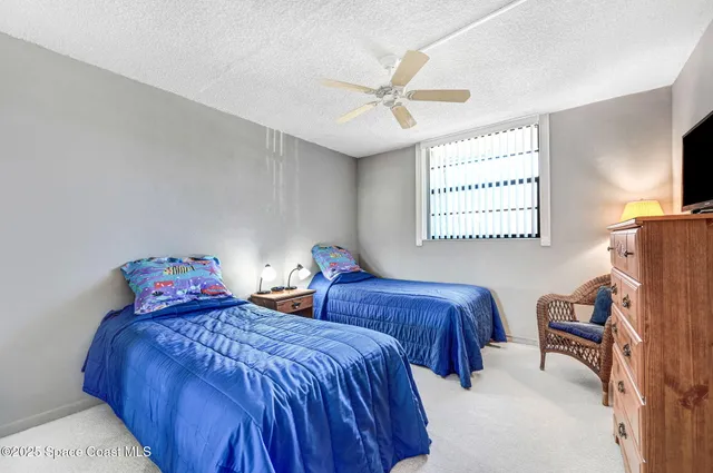 a bedroom with two beds and a desk