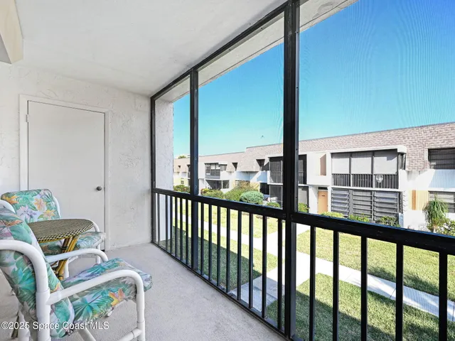 a view of a living room with furniture and floor to ceiling window