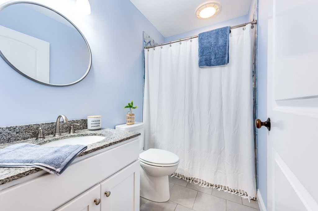 55 Paul Street Watertown, MA 02472 - Photo 22 of 42 a bathroom with a granite countertop sink and a mirror