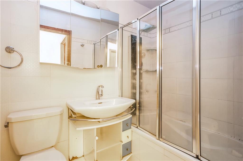 2944 West 5th Street, Unit 14F Brooklyn, NY 11224 - Photo 10 of 13 a bathroom with a sink a toilet and shower