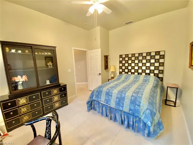 a bedroom with a bed and a flat tv screen on dresser