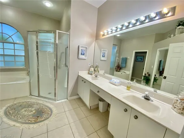 a bathroom with a tub a double vanity sink a vanity and a mirror