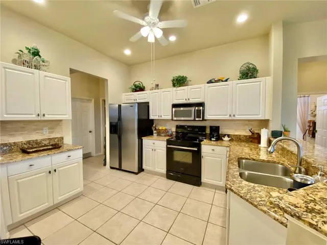 a kitchen with granite countertop a sink stainless steel appliances and cabinets