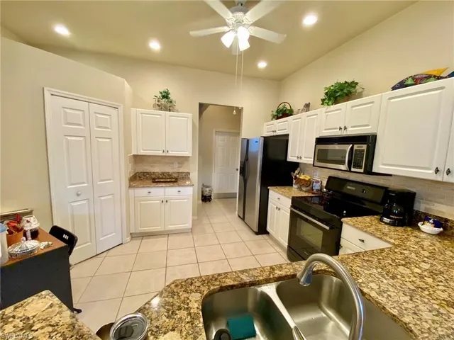 a kitchen with a sink stainless steel appliances and white cabinets