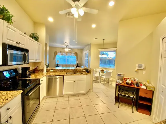 a kitchen with stainless steel appliances kitchen island granite countertop a table and chairs in it