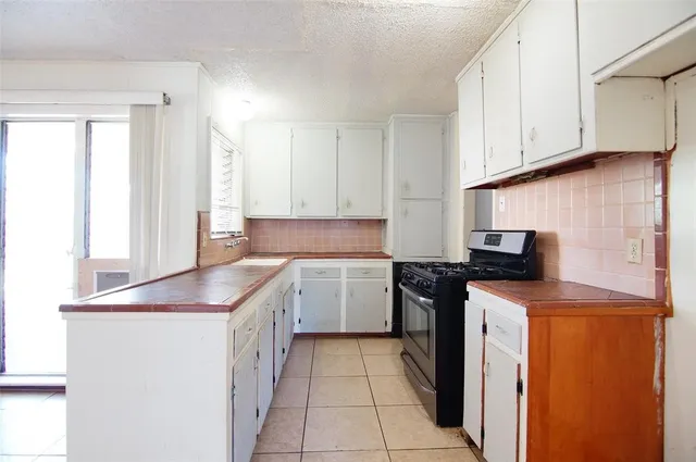 a kitchen with a sink and a stove top oven