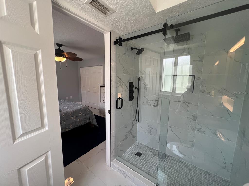2704 2nd Street, Unit 7 Indian Rocks Beach, FL 33785 - Photo 11 of 32 a bathroom with a tub shower and mirror