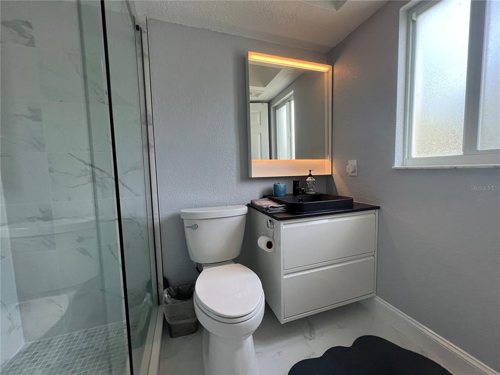 2704 2nd Street, Unit 7 Indian Rocks Beach, FL 33785 - Photo 12 of 32 a bathroom with a toilet a sink and a window