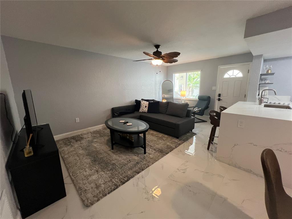 2704 2nd Street, Unit 7 Indian Rocks Beach, FL 33785 - Photo 16 of 32 a living room with furniture and a chandelier
