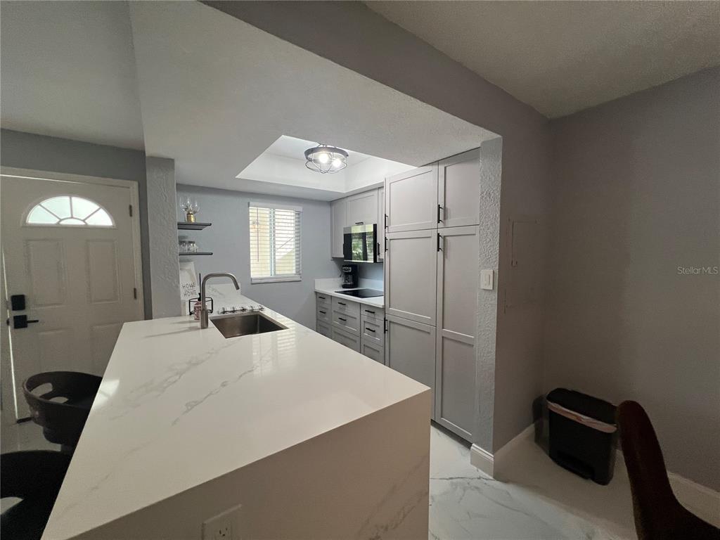 2704 2nd Street, Unit 7 Indian Rocks Beach, FL 33785 - Photo 18 of 32 a kitchen with a refrigerator and a sink