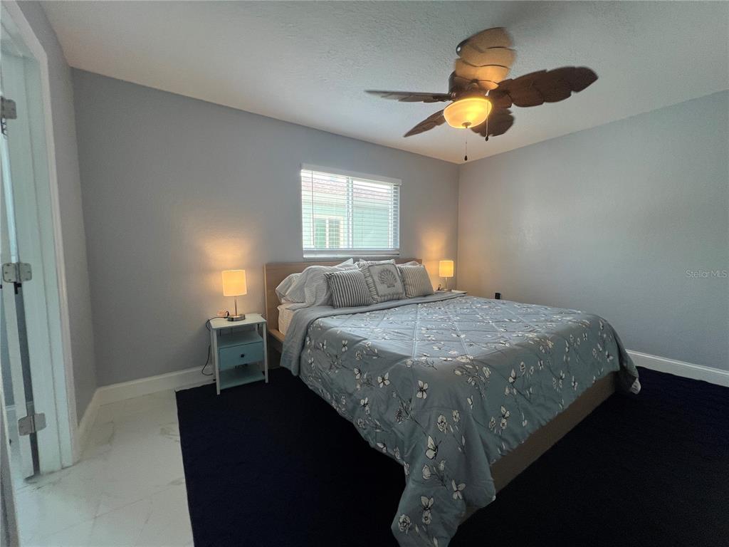 2704 2nd Street, Unit 7 Indian Rocks Beach, FL 33785 - Photo 21 of 32 a bedroom with a bed and a chandelier