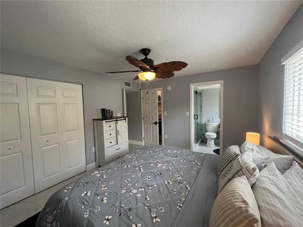 2704 2nd Street, Unit 7 Indian Rocks Beach, FL 33785 - Photo 23 of 32 a bed room with a bed and a ceiling fan