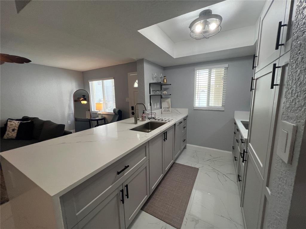 2704 2nd Street, Unit 7 Indian Rocks Beach, FL 33785 - Photo 5 of 32 a large white kitchen with a window a sink and a refrigerator