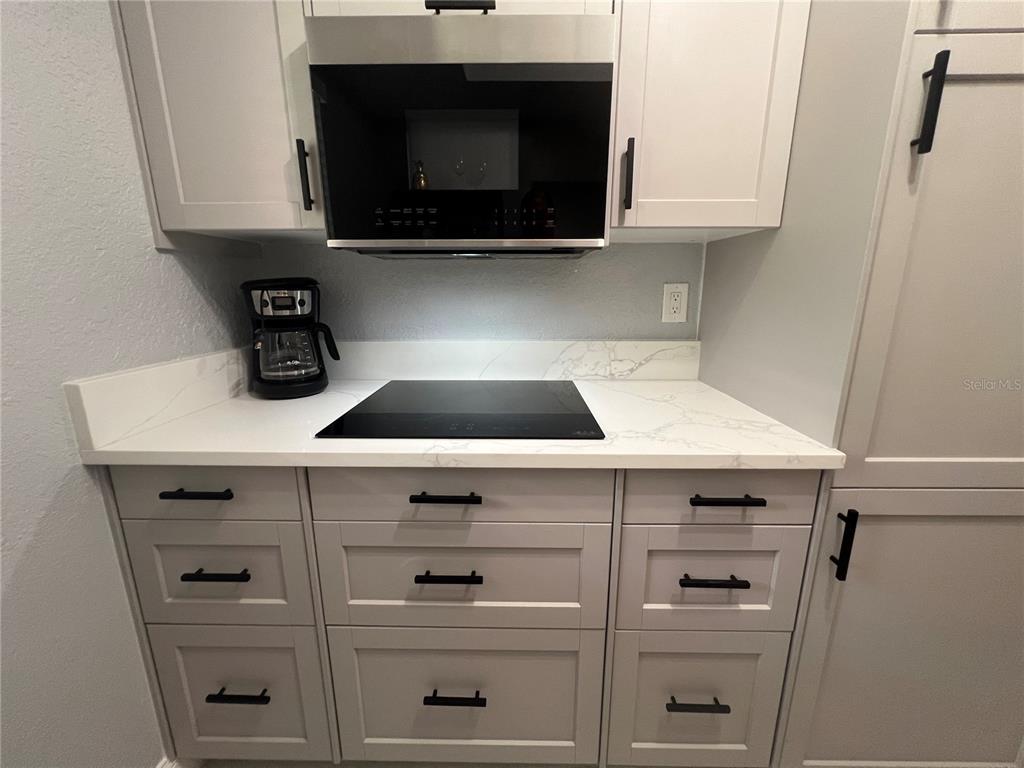 2704 2nd Street, Unit 7 Indian Rocks Beach, FL 33785 - Photo 6 of 32 a close view of a stove a microwave and cabinets