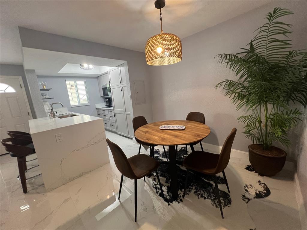 2704 2nd Street, Unit 7 Indian Rocks Beach, FL 33785 - Photo 7 of 32 a view of a dining room with furniture and chandelier