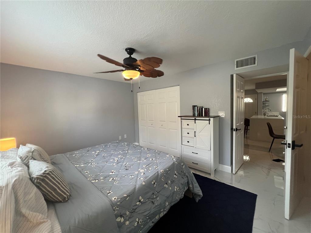 2704 2nd Street, Unit 7 Indian Rocks Beach, FL 33785 - Photo 8 of 32 a bedroom with a bed and a chandelier