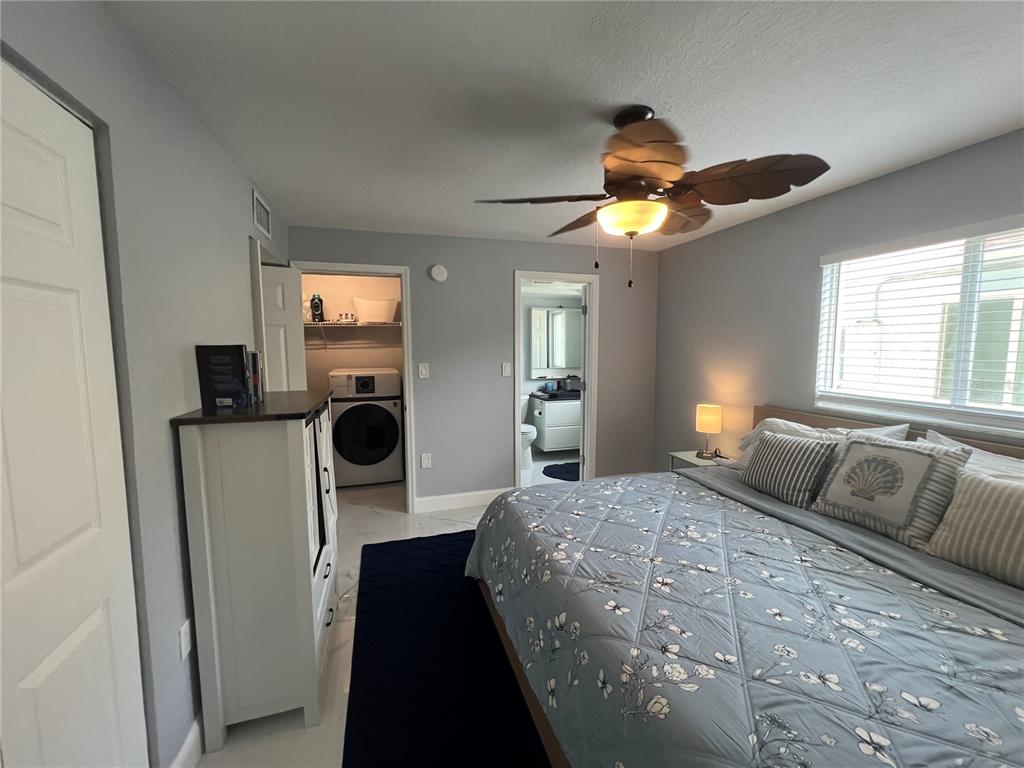 2704 2nd Street, Unit 7 Indian Rocks Beach, FL 33785 - Photo 9 of 32 a bedroom with a bed and a chandelier