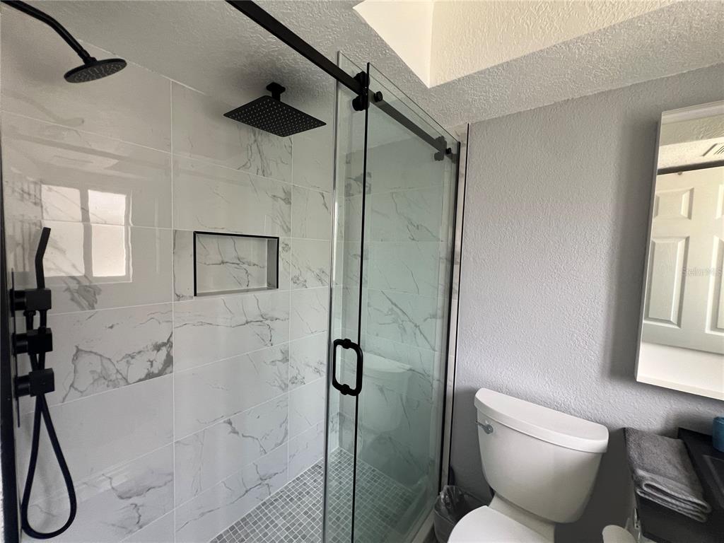 2704 2nd Street, Unit 7 Indian Rocks Beach, FL 33785 - Photo 10 of 32 a bathroom with a toilet sink and shower