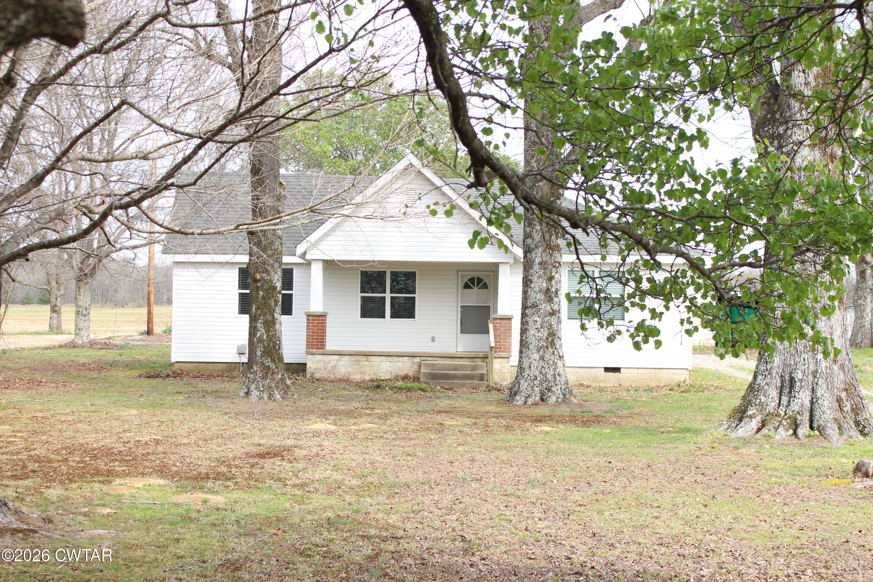 8860 Highway 138 Mercer, TN 38392 - Photo 2 of 23 a white house that has a tree in front of it