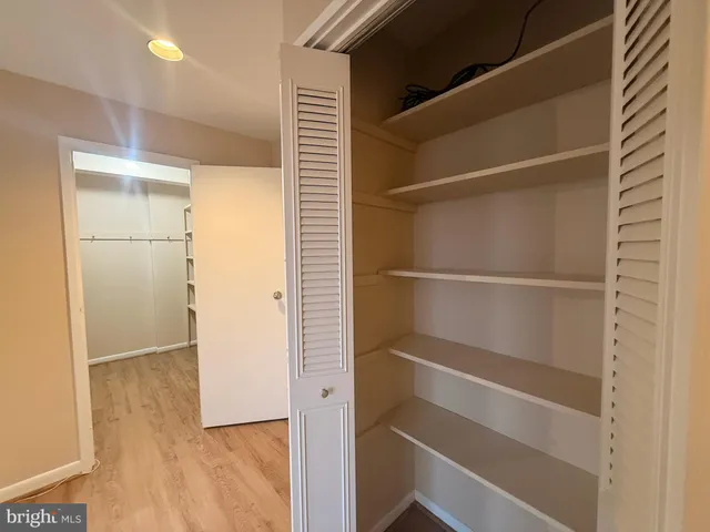 a view of walk in closet with empty racks
