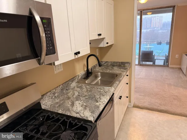 a kitchen with a sink stove and cabinets