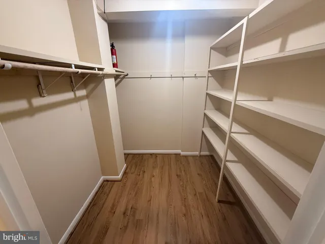 a view of walk in closet with wooden floor