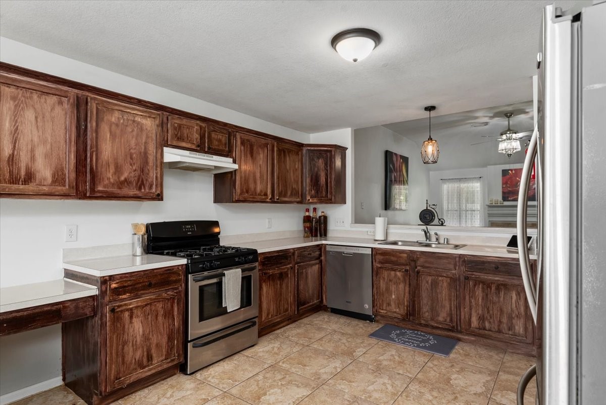22711 Tree House Lane Spring, TX 77373 - Photo 12 of 28 a kitchen with stainless steel appliances a stove sink and cabinets