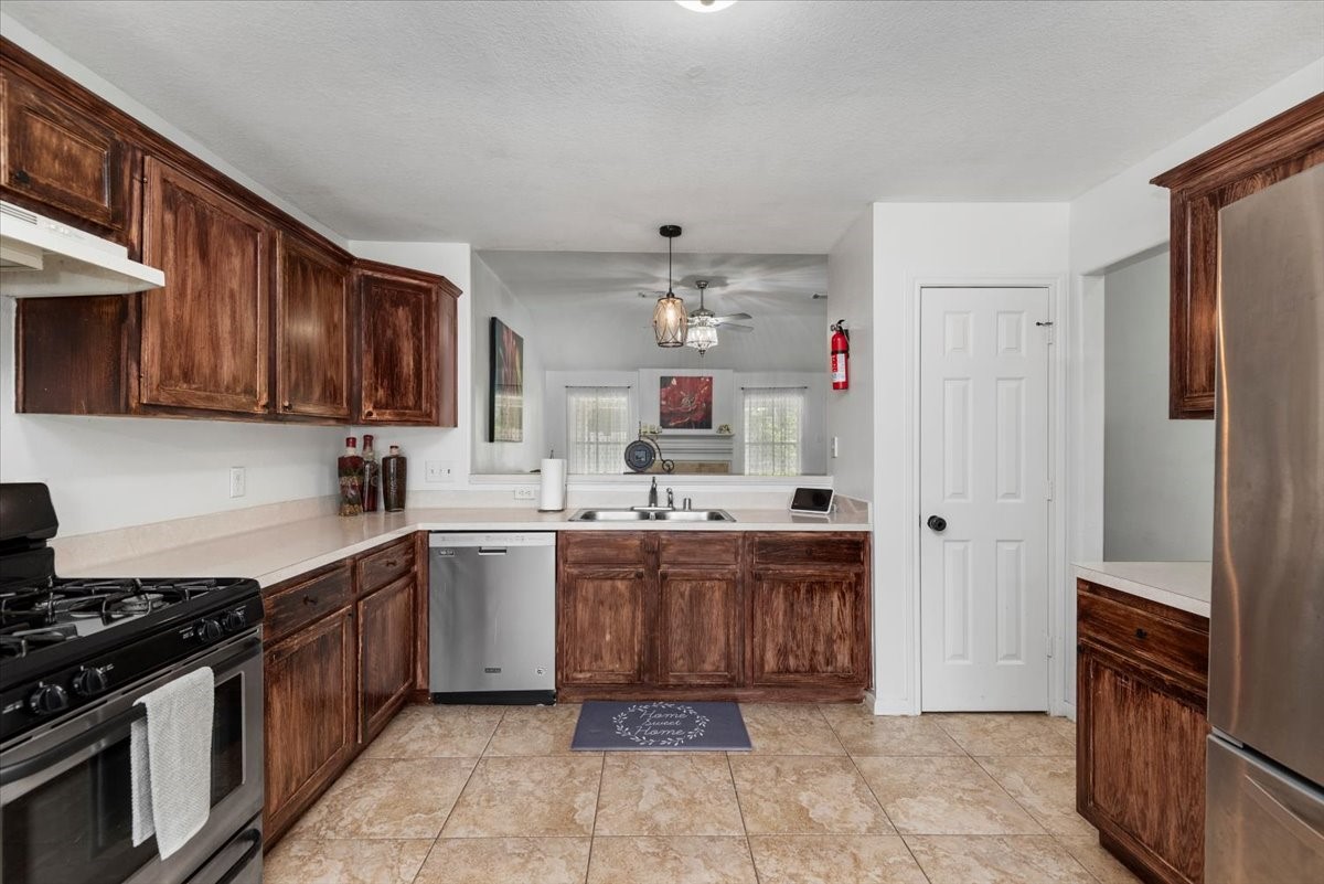 22711 Tree House Lane Spring, TX 77373 - Photo 13 of 28 a kitchen with kitchen island stainless steel appliances a stove sink and cabinets