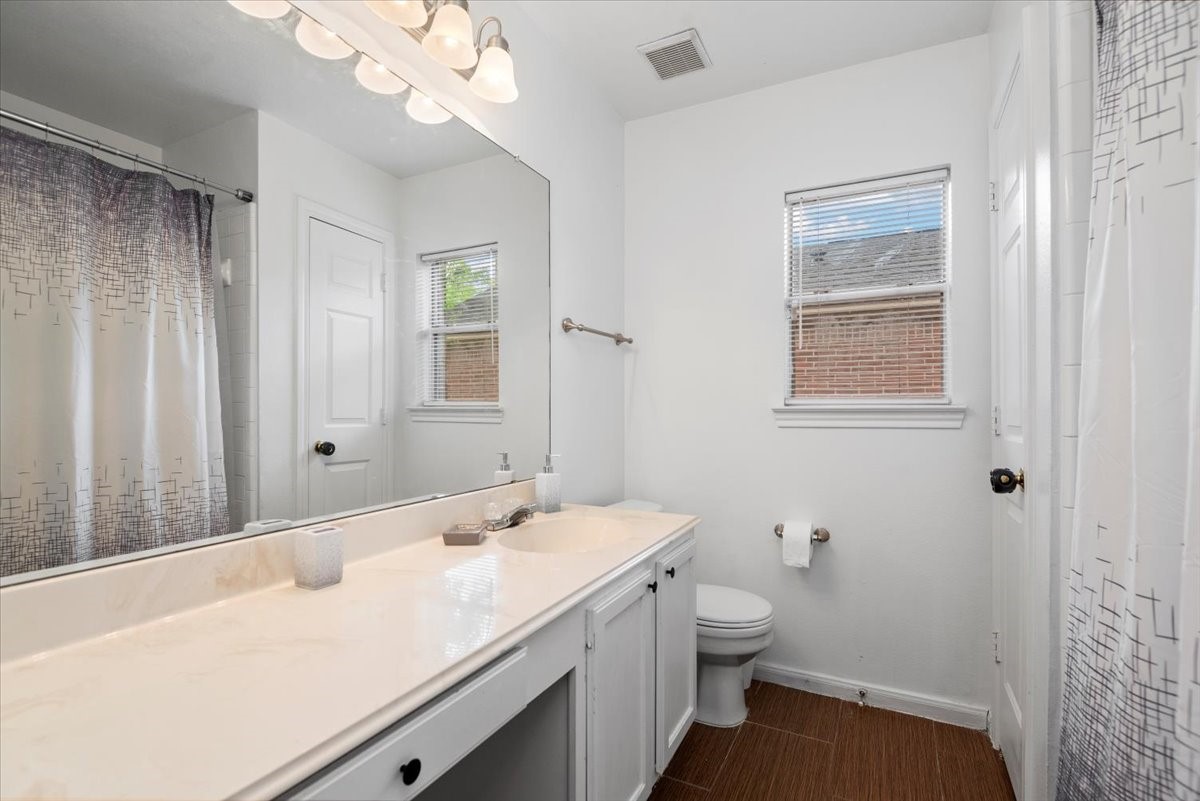 22711 Tree House Lane Spring, TX 77373 - Photo 20 of 28 a bathroom with a sink a toilet and a mirror