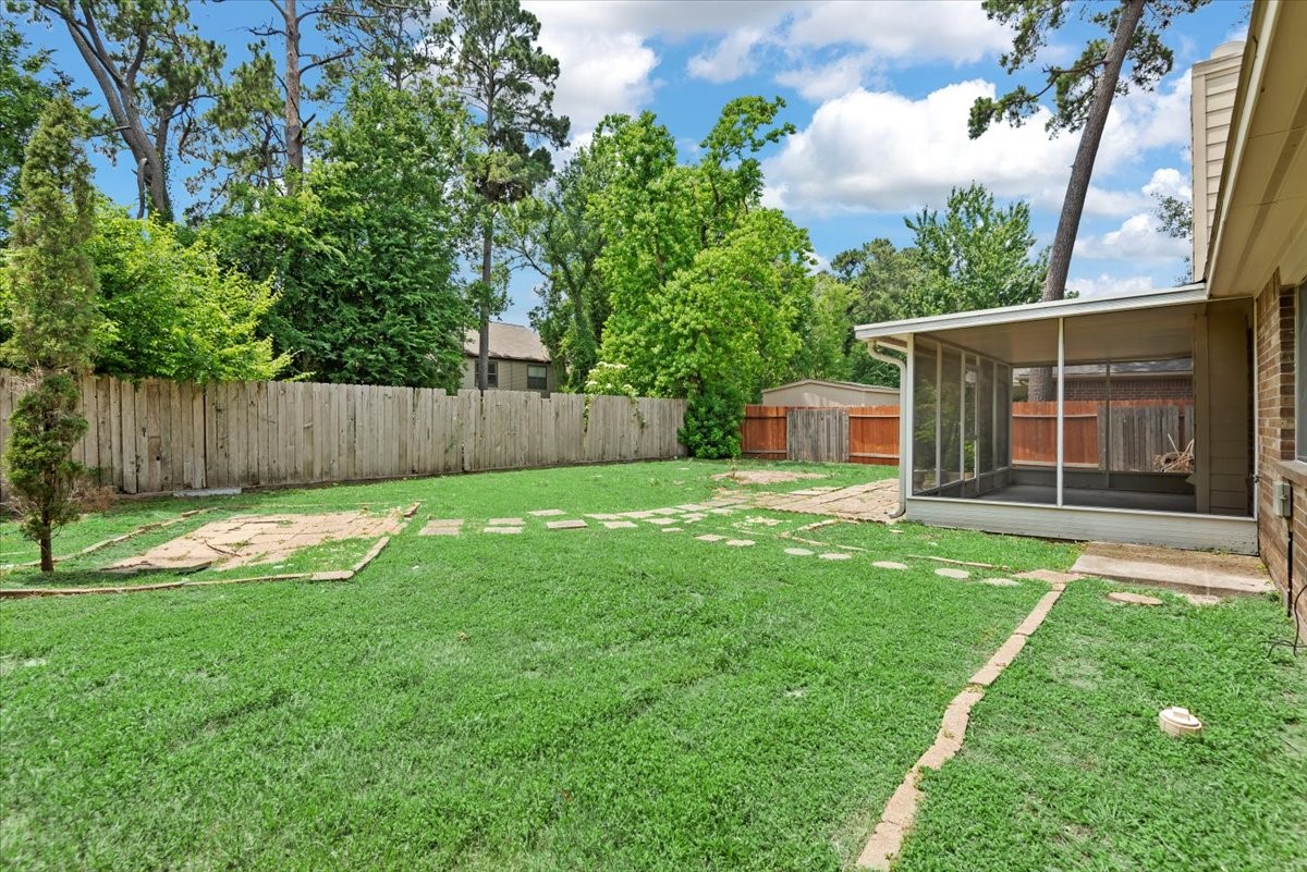 22711 Tree House Lane Spring, TX 77373 - Photo 27 of 28 a view of a backyard with a large tree and wooden fence