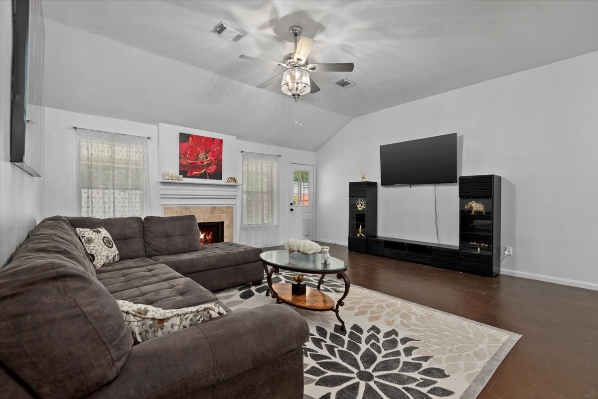 22711 Tree House Lane Spring, TX 77373 - Photo 6 of 28 a living room with furniture a flat screen tv and a fireplace