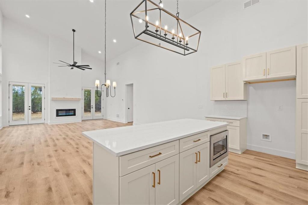 419 Lively Road Waco, GA 30182 - Photo 21 of 48 a kitchen with white cabinets and wooden floor