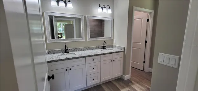 a bathroom with a granite countertop sink double and mirror