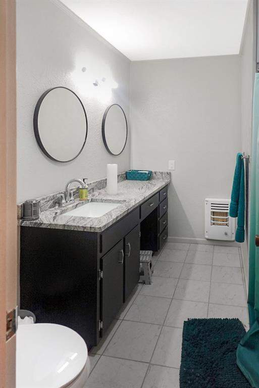 403 West Tarleton Street Stephenville, TX 76401 - Photo 16 of 19 a bathroom with a toilet a sink and a mirror