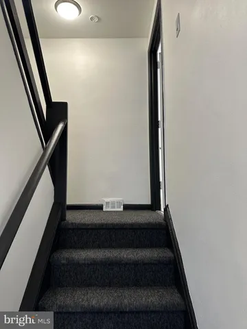 a view of staircase with white walls and a window