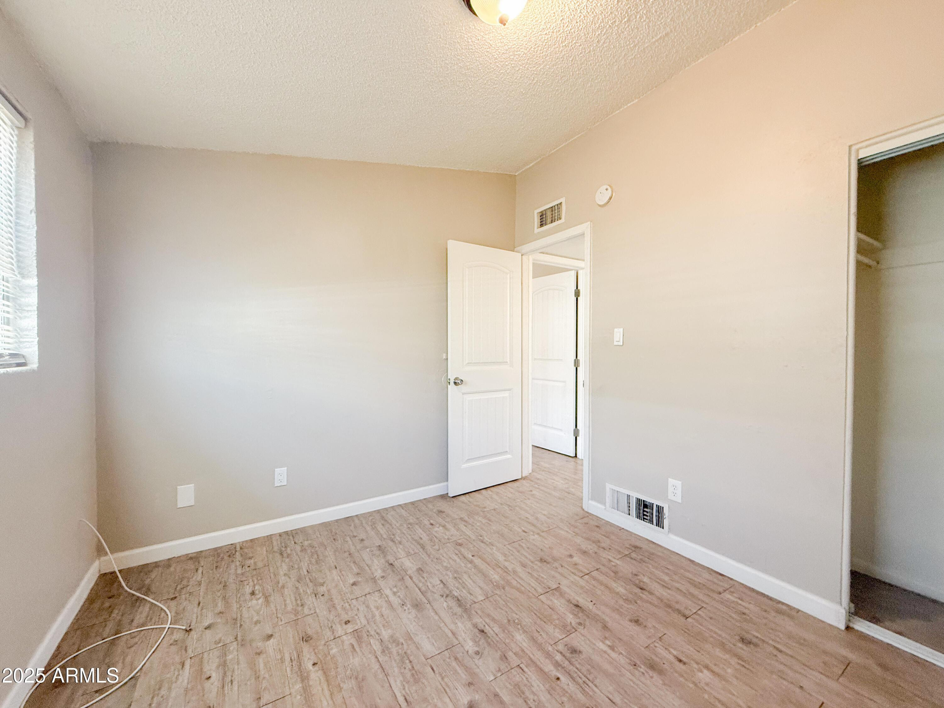 2123 West Devonshire Avenue, Unit 15 Phoenix, AZ 85015 - Photo 14 of 14 an empty room with wooden floor and windows