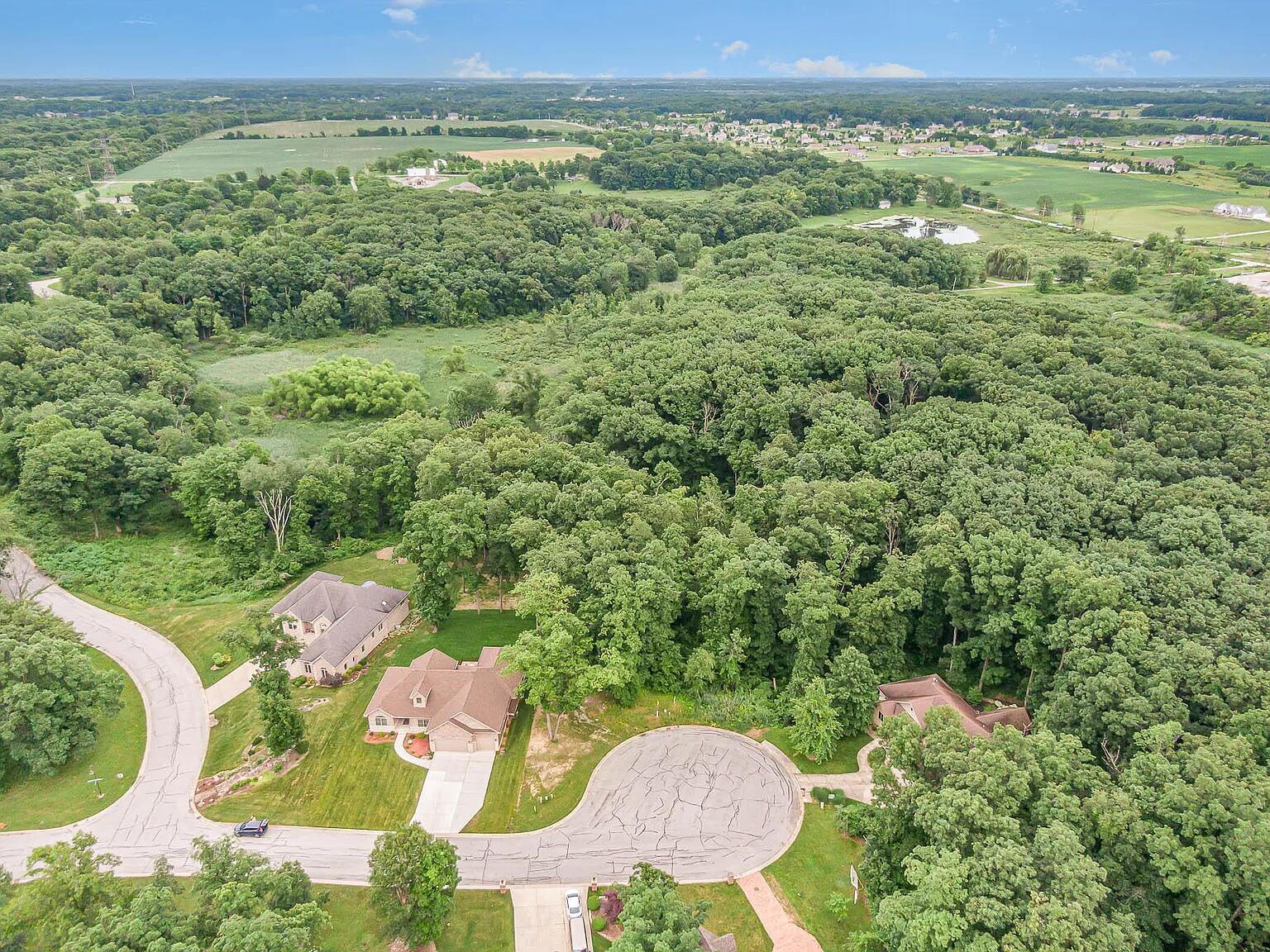 an aerial view of a house with outdoor space and a lake view