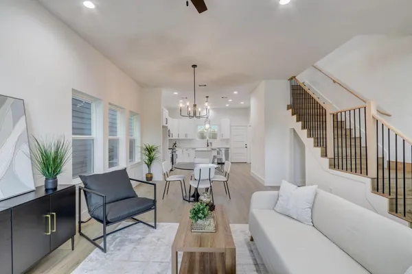 a living room with furniture a chandelier and a dining room
