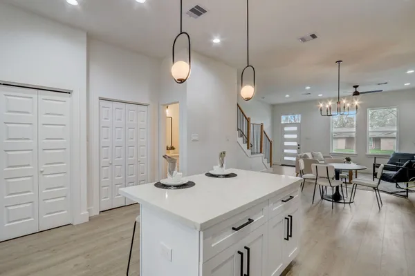 a kitchen with a table chairs and wooden floor
