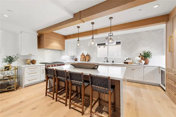 a kitchen with stainless steel appliances kitchen island granite countertop dining table chairs and white cabinets